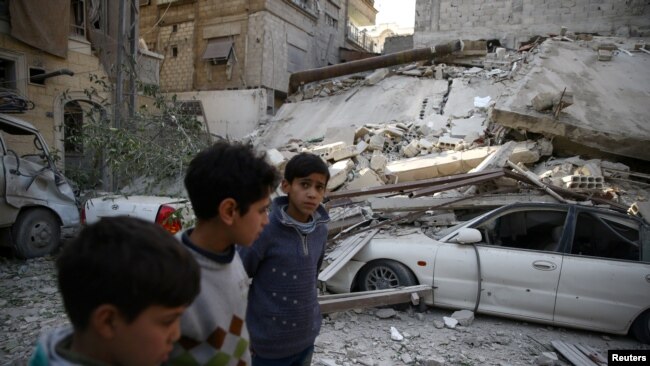 Niños caminan entre escombros después de una ataque aéreo en Ghouta Oriental, Siria, el 6 de febrero de 2018.