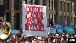 Des manifestants brandissent une pancarte indiquant "contre Macron, pas de division", lors d'une manifestation baptisée " fête à Macron " à l'occasion du premier anniversaire de son élection, Paris, 5 mai 2018.