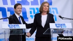 Issac Herzog (L), leader of Israel's Labour party, and former Justice Minister Tzipi Livin shake hands after their joint news conference in Tel Aviv, Dec. 10, 2014.