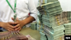 Nhân viên ngân hàng chuẩn bị tiền mặt cho khách giao dịch tại một ngân hàng ở Hà Nội, Việt Nam, ngày 13 tháng 5 năm 2015.