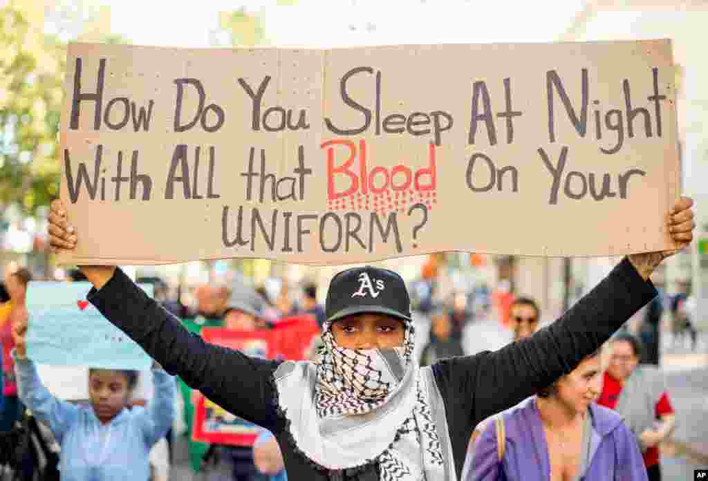 Mwanamke akiwa ameshika bango wakati wa maandamano dhidi ya kupigwa risasi ya Michael Brown.Oakland,Calif,Agosti,20,2014.