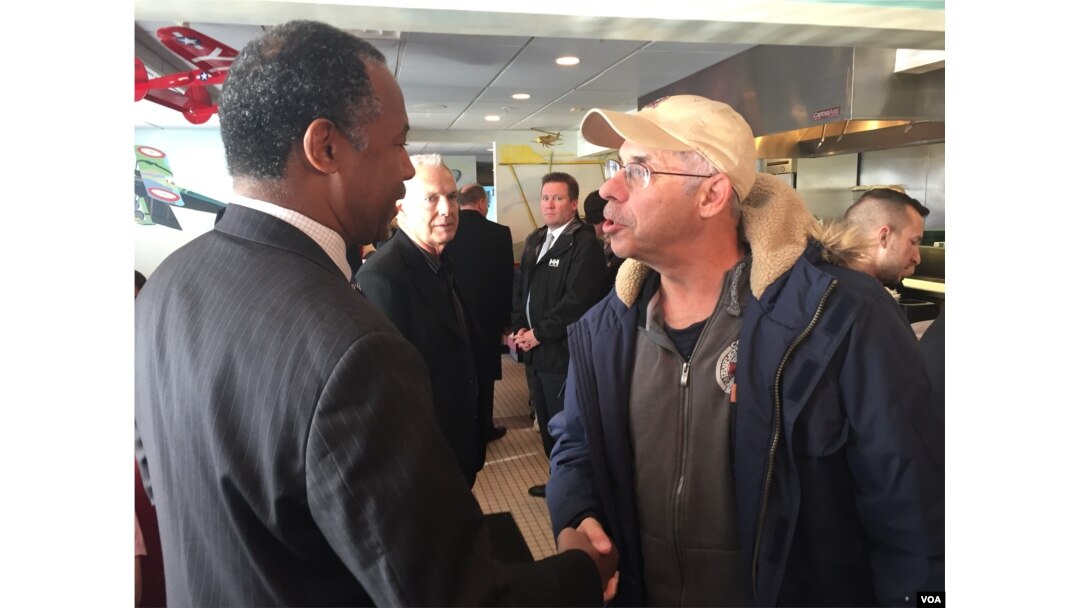 Presidential candidate Dr. Ben Carson shakes the hand of a local resident at the Airport Diner in Manchester, New Hampshire, Feb 7, 2016. (K. Gypson/VOA)