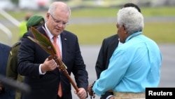 Australian Prime Minister Scott Morrison is presented with a gift as he arrives in Port Vila, Vanuatu, Jan. 16, 2019.