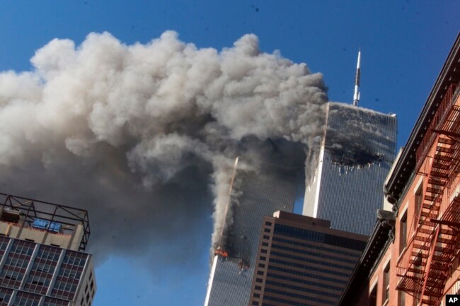FILE - Smoke rises from the burning twin towers of the World Trade Center after hijacked planes crashed into them, in New York City, Sept. 11, 2001.