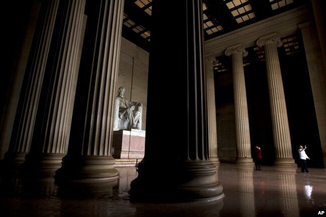 Visitors take their pictures at the Lincoln Memorial in Washington, Tuesday, Jan. 1, 2019, as a partial government shutdown stretches into its third week.