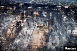 Rumah-rumah dan pepohonan yang hangus setelah kebakaran hebat yang melanda desa Mati, dekat Athena, Yunani, 25 Juli 2018, dilihat dari udara.