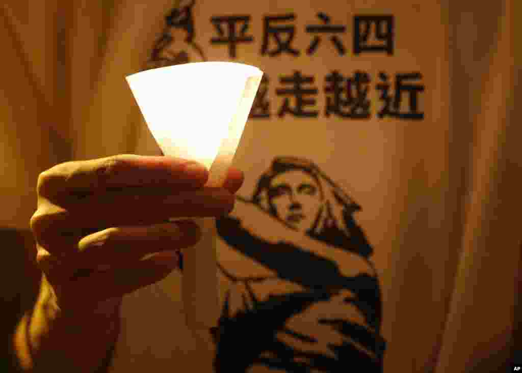 A man wears a T-shirt with Chinese reading "Vindicate June 4" at a candlelight vigil at Hong Kong's Victoria Park in Hong Kong Monday June 4, 2012 to mark the 23rd anniversary of the Chinese military crackdown on the pro-democracy movement in Beijing. 