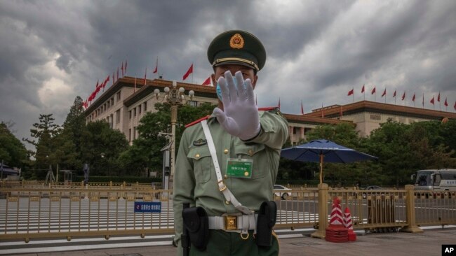 资料照：中国武警士兵做出禁止给北京人大会堂拍照的手式 。（2020年5月25日）