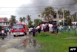 Onlookers watching as firefighters attempt to extinguish fires from houses burnt by Rohingya militants in Maungdaw township in Rakhine State in Myanmar, Aug. 27, 2017.