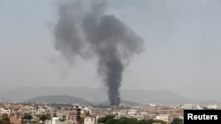 沙特阿拉伯为首的联盟武装发动的空袭，击中了也门首都萨那的一家快餐加工厂。图为这家工厂被击中后冒烟。无国界医生组织说，在这次空袭中有28人受伤。（资料照片）