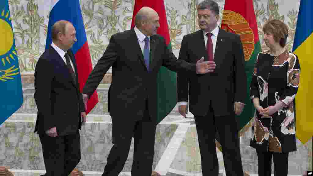 Belarusian President Alexander Lukashenko, second left, welcomes Russian President Vladimir Putin, left, Ukrainian President Petro Poroshenko, second right, and EU foreign policy chief Catherine Ashton, right, to their talks after after posing for a phot