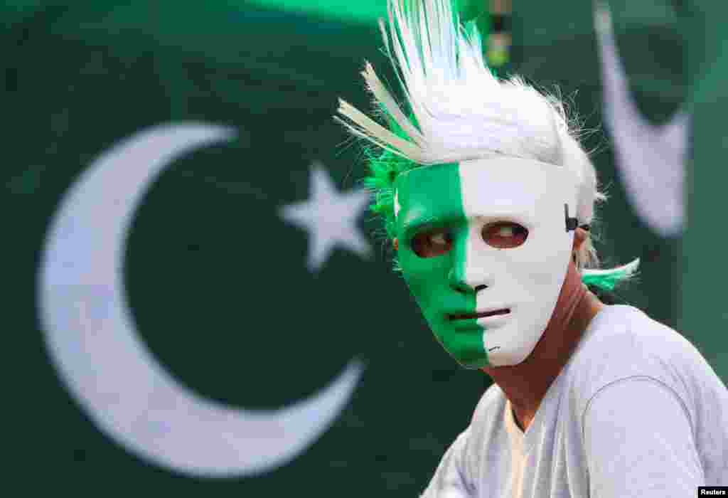 A vendor wears a mask with the colors of the Pakistani flag at a roadside stall in Islamabad as people prepare to celebrate the country's Independence Day on August 14.