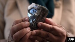 Un membre du cabinet du Botswana détient un diamant de 1 174 carats à Gaborone, au Botswana, le 7 juillet 2021, que le Lucara Botswana a trouvé au cours d'une production de onze jours en juin 2021.