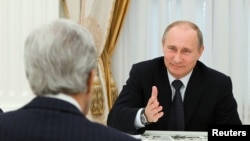 Russian President Vladimir Putin (R) speaks to U.S. Secretary of State John Kerry during their meeting in the Kremlin in Moscow, May 7, 2013. 