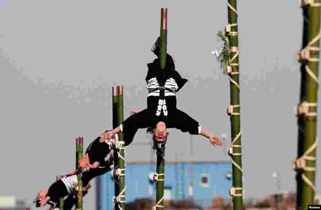 សមាជិកនៃសមាគម Edo Firemanship Preservation Association បង្ហាញជំនាញទប់ខ្លួនរបស់គេនៅលើដើមឬស្សីនៅក្នុងកម្មវិធីមួយសម្រាប់ពិធីឆ្លងឆ្នាំថ្មីនៅនាយកដ្ឋានពន្លត់អគ្គិភ័យតូក្យូ នៅក្នុងក្រុងតូក្យូ ប្រទេសជប៉ុន កាលពីថ្ងៃទី៦ ខែមករា ឆ្នាំ២០១៨។