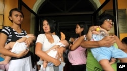 Mothers cuddle their babies as they undergo medical checkup at Cainta Town Hall at Cainta township, Rizal province east of Manila, Philippines, October 8, 2009.