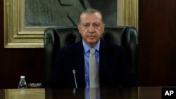 Turkey's President Recep Tayyip Erdogan chairs a government meeting in Ankara, Oct. 25, 2018. Erdogan says his country is determined not to allow anyone responsible for Saudi journalist Jamal Khashoggi's killing to escape justice. 