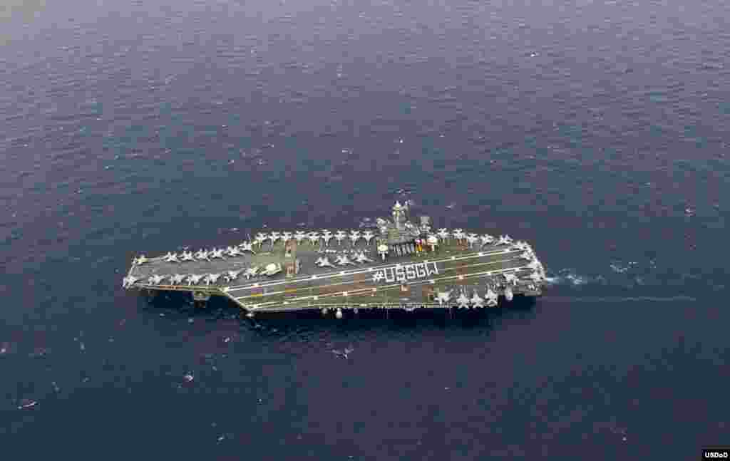 Para pelaut yang ditugaskan di kapal induk Angkatan Laut AS USS George Washington (USSGW) berdiri membentuk formasi USSGW di dek kapal induk tersebut. 
