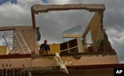 A woman works to recover belongings from her home destroyed by a tornado in Regla, Cuba, Jan. 28, 2019.