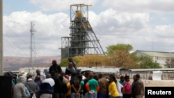 FILE - Miners gather near the Anglo American Platinum's Thembelani mine near the mining town of Rustenburg, northwest of Johannesburg Sept. 30, 2013. 