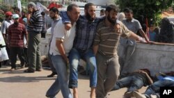 An injured man is brought to a makeshift hospital after Egyptian soldiers and police opened fire on supporters of the ousted President Mohammed Morsi early Monday in Cairo, Egypt, Monday, July 8 , 2013. The violence left dozens people killed outside the