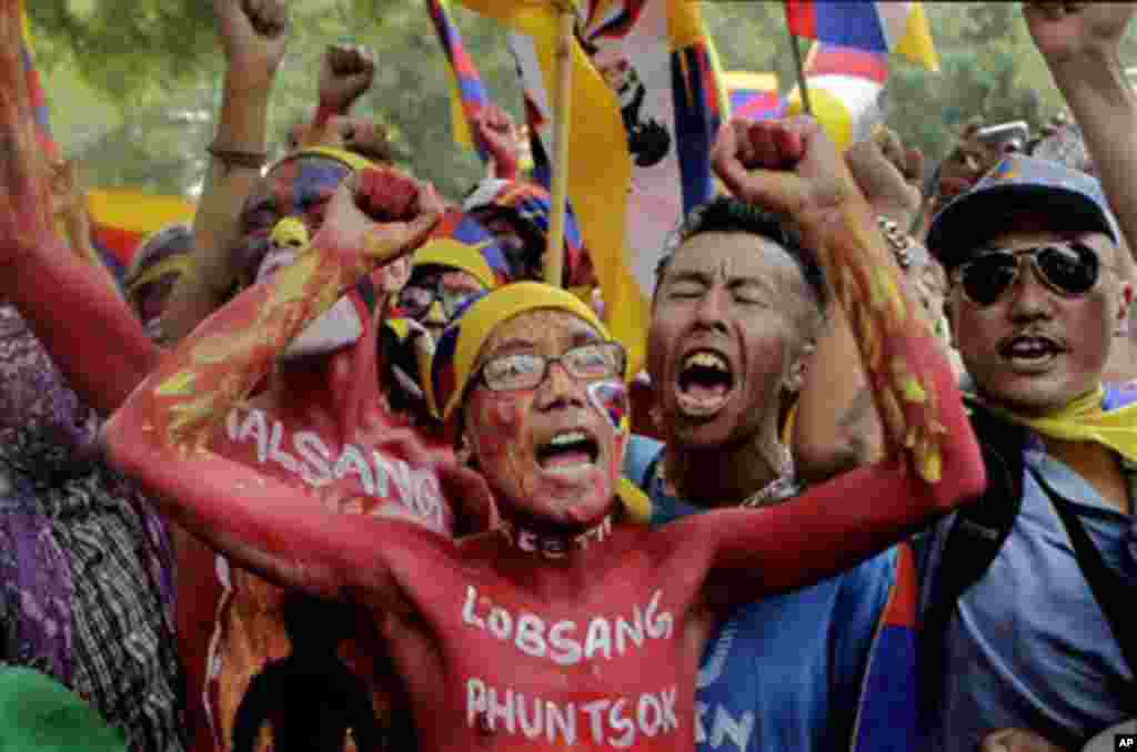 Exile Tibetans, with painted bodies and names of monks who self-immolated themselves, shout slogans in a protest march in New Delhi, India, Friday, Oct. 21, 2011.