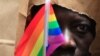 FILE - An asylum seeker from Uganda covers his face with a paper bag to protect his identity as he marches with the LGBT Asylum Support Task Force during the Gay Pride Parade in Boston, Massachusetts, June 8, 2013.