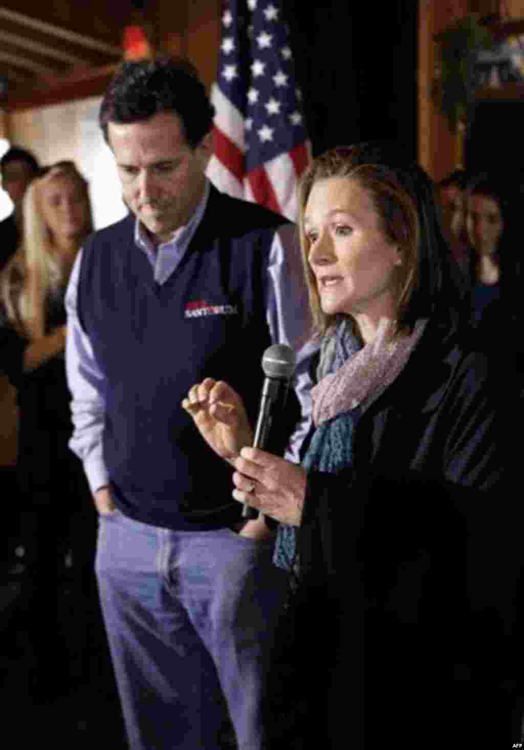 Republican presidential candidate, former Pennsylvania Sen. Rick Santorum listens at left as his wife Karen speak at Hudson's BBQ in Lexington, S.C., Friday, Jan. 20, 2012. (AP Photo/Paul Sancya)