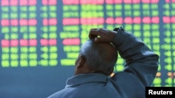 FILE - An investor looks at an electronic screen showing stock information at brokerage house in Hangzhou, Zhejiang Province, China, Jan. 11, 2016. 