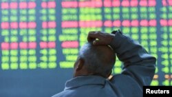 An investor looks at an electronic screen showing stock information at brokerage house in Hangzhou, Zhejiang Province, China, Jan. 11, 2016. 