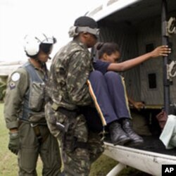 United Nations Stabilization Mission in Haiti (MINUSTAH) peacekeepers load an injured employee of Port-au-Prince's now-collapsed Hotel Montana onto a helicopter after a potent earthquake rocked the Haitian capital, 13 Jan 2010