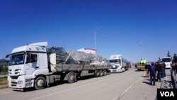 Trucks carry tents and construction material to be used for make-shift refugee housing, in Oncupinar, Turkey, Feb. 8, 2016. The supplies are destined for refugees on Syrian territory whom Ankara refuses entry into Turkey. (Photo - J. Dettmer/VOA)
