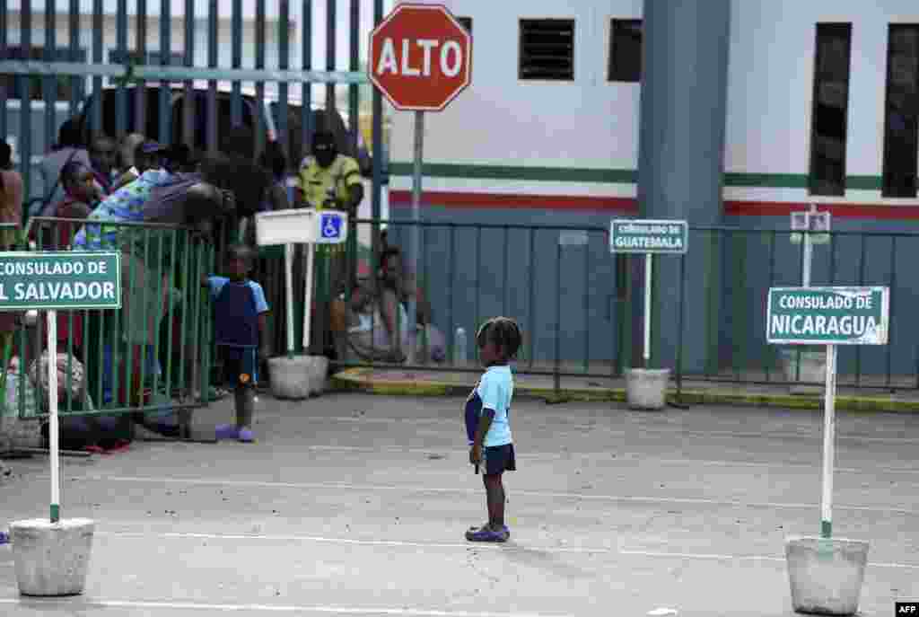 A migrant child is pictured as migrants of different nationalities wait outside the Mexican National Institute of Migration in Tapachula, Chiapas State.