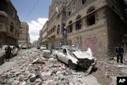 People inspect the site of an airstrike by Saudi-led coalition in Sanaa, Yemen, May, 16, 2019.