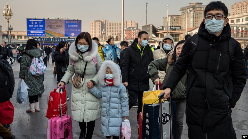 2020年1月21日北京火车站戴着口罩的人群回家过新年。