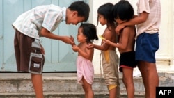 FILE - Cambodian orphans play together as they wait for adoption at an orphanage in Phnom Penh, June 22, 2000. 