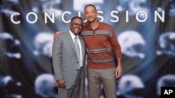 FILE - In this Dec. 14, 2015, file photo, Dr. Bennet Omalu, left, and actor Will Smith pose together at the cast photo call for the film "Concussion" at The Crosby Street Hotel in New York. The movie releases in U.S. theaters on Dec. 25, 2015. 