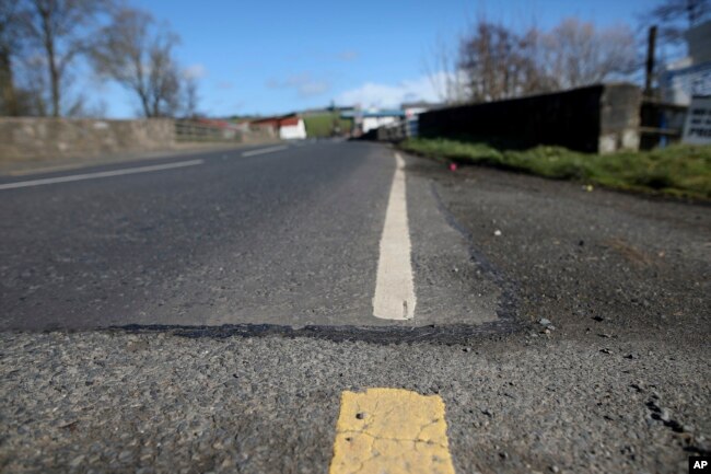 FILE - The Irish border, near the town of Middletown, Northern Ireland, March, 12, 2019. All that marks the border crossing is the change in paint and a cut in the tarmac, with white paint being in Northern Ireland and yellow paint used in the Republic of Ireland.