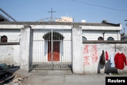 FILE - A closed Catholic Church is seen at a relocated wholesale market in Shanghai, China February 15, 2017. The sign reads: "Do not defecate". REUTERS/Aly Song