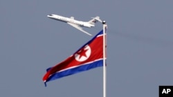 지난해 9월 북한 원산 시에서 고려항공 여객기가 인공기 너머로 날고 있다.