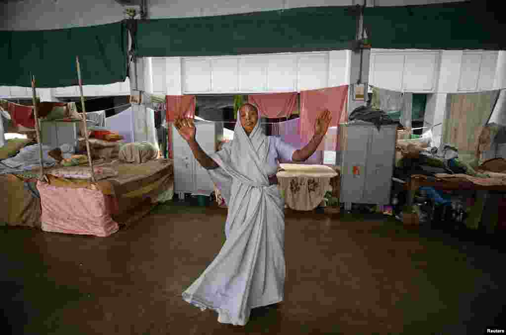 Seorang janda menari di sebuah asrama di Vrindavan, negara bagian Uttar Pradesh, dalam perayaan Holi atau festival warna (24/3). (Reuters/Vivek Prakash)