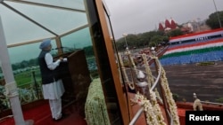 India's Prime Minister Manmohan Singh addresses the nation from a bullet-proof enclosure at the historic Red Fort during Independence Day celebrations in Delhi, August 15, 2013.