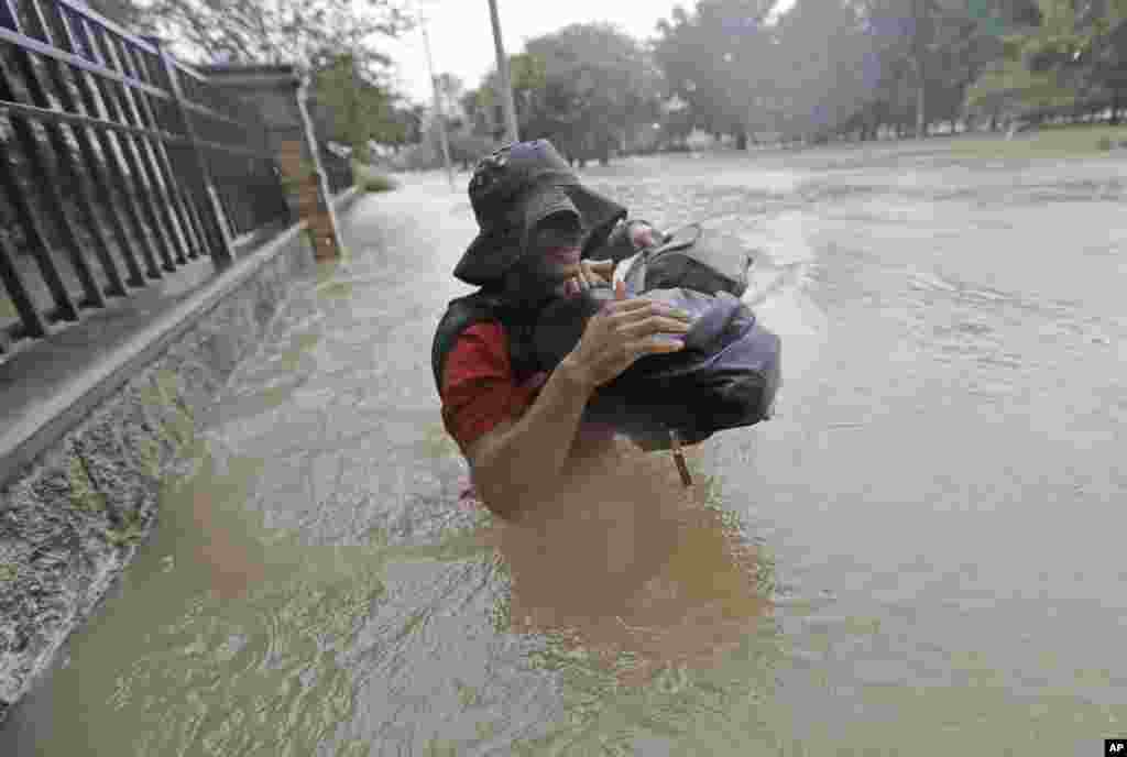 Residents wade through floodwaters from Tropical Storm Harvey, Aug. 27, 2017, in Houston, Texas.