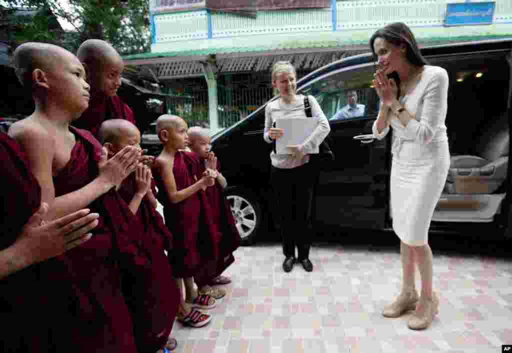 Angelina Jolie, right, pays respect to Buddhist novice monks upon arrival at a monastery to meet with religious leaders from the Myanmar Interfaith Group in Yangon. The Hollywood actress arrived in Myanmar, for her first visit to the country Thursday to learn more about the situation in the country and encourage efforts to build a peaceful and inclusive future for all its people.