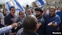 Israeli right-wing activists confront a security official near the Western Wall inside the old city of Jerusalem, Oct. 30, 2014. 