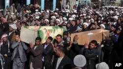Mourners carry the coffins of two slain pilgrims killed in a bombing in the Shiite city of Najaf, 160 kilometers (100 miles) south of Baghdad, Iraq, February 13, 2011.