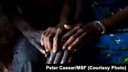 Jean-Pierre, patient du VIH et de la tuberculose, est consolé par une proche à Kinshasa, le 15 novembre 2020. 