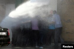 FILE - Turkish riot police use water cannon to disperse Kurdish demonstrators protesting against the removal of the local mayor from office over suspected links with Kurdish militants, in Diyarbakir, Turkey, Sept. 11, 2016.