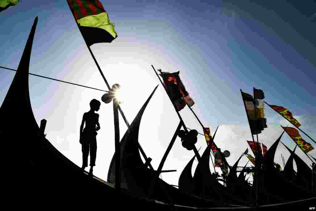 A Rohingya refugee boy looks on as he stands on a fishing boat at Shamlapur camp in Teknaf.