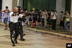 2019年7月30日一名香港警察舉槍瞄準了在香港葵涌警署大樓前聲援被拘捕的反送中抗議者的示威人群。